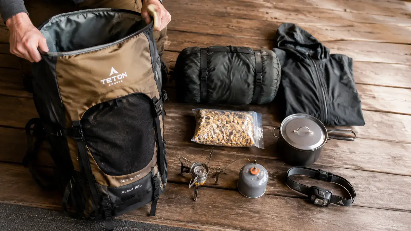 Gear spread laid out next to the TETON Scout 55L showing how a weekend hunting camp load fits into the pack